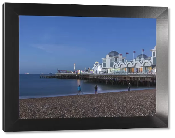 England, Hampshire, Portsmouth, Southsea, Men Fishing on Beach in front of Southsea Pier