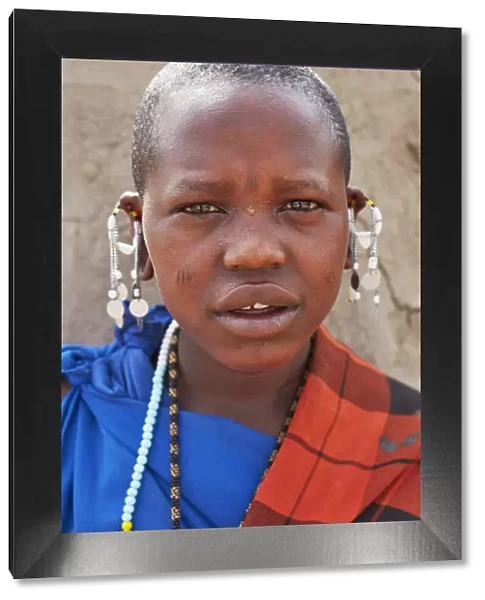 Portrait of a young Msai girl with a traditional Shuka dress in a village near Arusha, Tanzania, Africa
