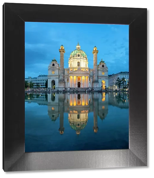 Reflection of illuminated Karlskirche at Karlsplatz at twilight, Innere Stadt, Vienna, Austria
