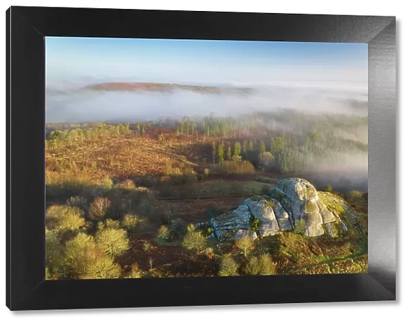 Aerial view of Blackingstone Rock on a misty winter morning, Dartmoor National Park, Devon, England. Winter (March) 2022
