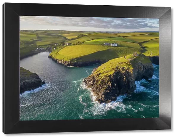 Aerial view of Port Quin surrounded by rugged Cornish coastline, Cornwall, England. Spring (June) 2022