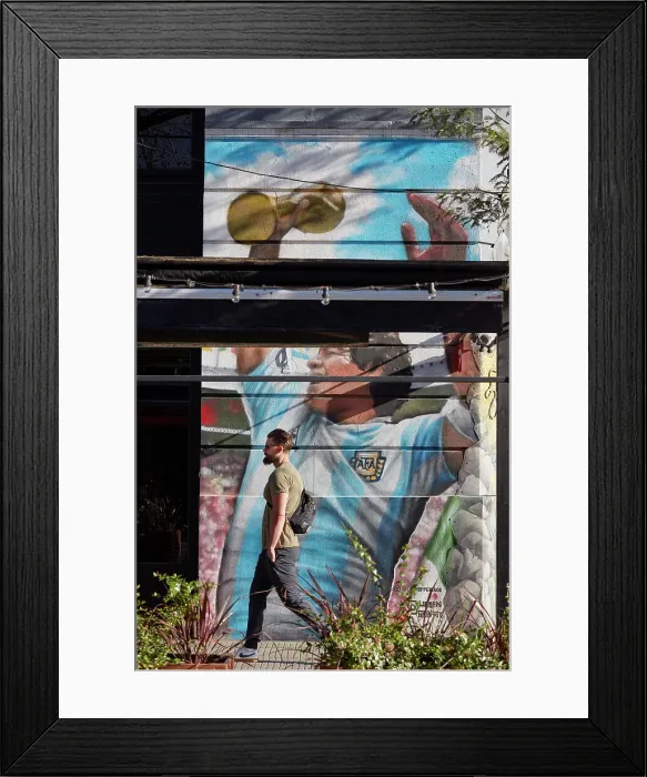 Framed Print : A person passing by a wall art mural of Diego Armando Maradona in the district of Palermo, Buenos Aires, Argentina Framed Print : A person passing by a wall art mural of Diego Armando Maradona in the district of Palermo, Buenos Aires, Argentina
