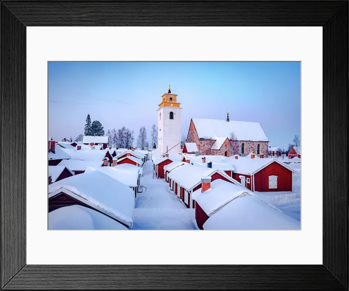 Framed Print : Roofs of cottages and bell tower covered with snow in the picturesque village of Gammelstad Church Town at dusk, Lulea, Sweden