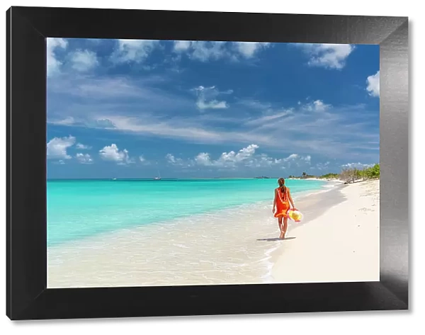 Beautiful woman in orange dress walking on a idyllic beach, Barbuda, Antigua & Barbuda, Caribbean, West Indies (MR)