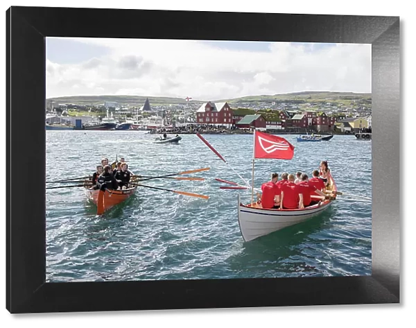 Rowing boats after a competion in occasion of 'lavsoka festival in the city of Torshavn. In the background the red buildings of Tinganes. Island of Streymoy. Faroe Islands