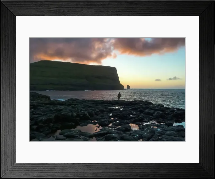 Framed Print : A hiker standing in front of the coast of the village of Eiði at sunset. In the backgroud the Rising and Kellingin sea stacks. Island of Eysturoy. Faroe Islands Framed Print : A hiker standing in front of the coast of the village of Eiði at sunset. In the backgroud the Rising and Kellingin sea stacks. Island of Eysturoy. Faroe Islands