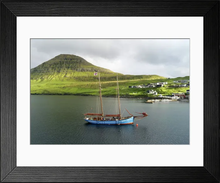 Framed Print : The Faroese-built wooden sailship Norðlysið (The Nordic Lights) sailing in fron of the village of Syðrugota. Island of Eysturoy. Faroe Islands