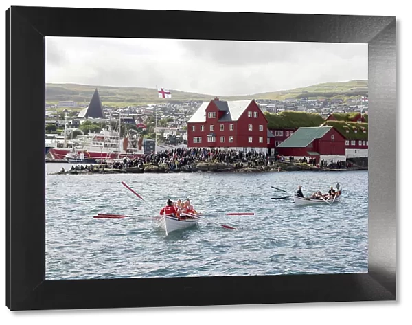 Two rowing boats after a competion in occasion of 'lavsoka festival in the city of Torshavn. In the background the red buildings of Tinganes. Island of Streymoy. Faroe Islands