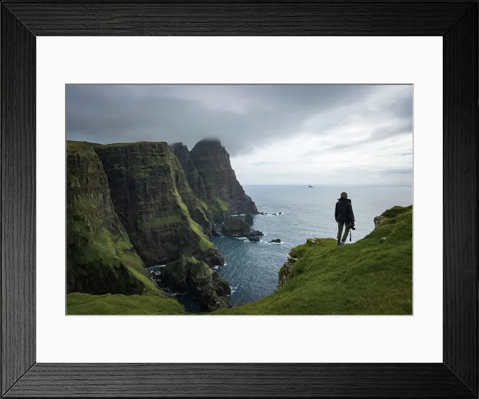 Framed Print : A hiker walking along the huge cliffs on the west coast of the islands of Suðuroy. In the backgound the cliff of Beinisvorð. Faroe Islands Framed Print : A hiker walking along the huge cliffs on the west coast of the islands of Suðuroy. In the backgound the cliff of Beinisvorð. Faroe Islands