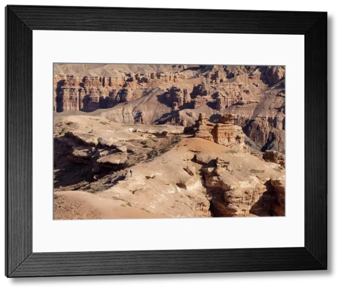 Framed Print : Kazakhstan, Charyn Canyon, a visitor walks through the canyon Framed Print : Kazakhstan, Charyn Canyon, a visitor walks through the canyon