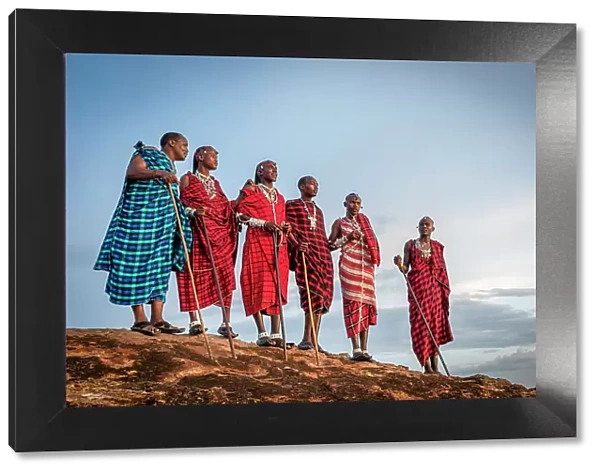 Africa, Tanzania, Manyara Region. A group of Msai men standing on a rock in the afternoon light