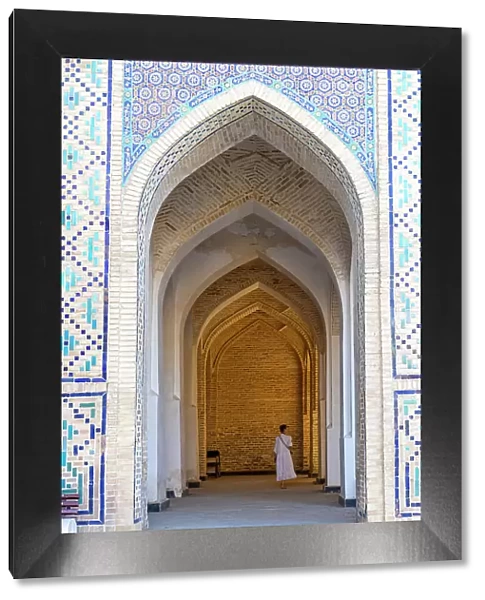 Uzbekistan, Bukhara, Po-i-Kalyan, Kalon Mosque, a tourist walks through an arched walkway