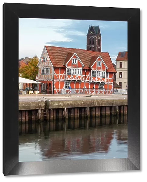 Half-timbered building called Gewolbe (The Vault) and tower of St. Marienkirche church in background, Wismar, UNESCO, Nordwestmecklenburg, Mecklenburg-Western Pomerania, Germany