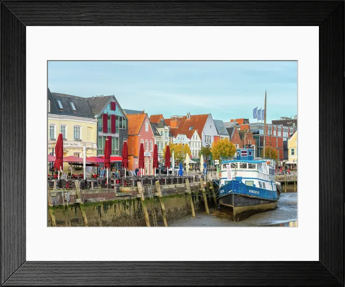 Framed Print : Houses with colorful facades on Hafenstrasse and boat at low tide, Husum, Nordfriesland, Schleswig-Holstein, Germany Framed Print : Houses with colorful facades on Hafenstrasse and boat at low tide, Husum, Nordfriesland, Schleswig-Holstein, Germany