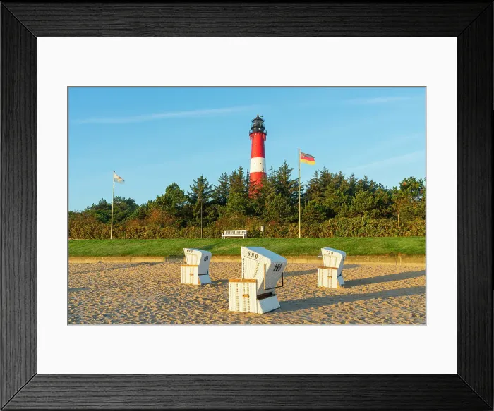 Framed Print : Beach chairs near German flag and Hornum lighthouse in background at sunrise, Hornum beach, Sylt, Nordfriesland, Schleswig-Holstein, Germany