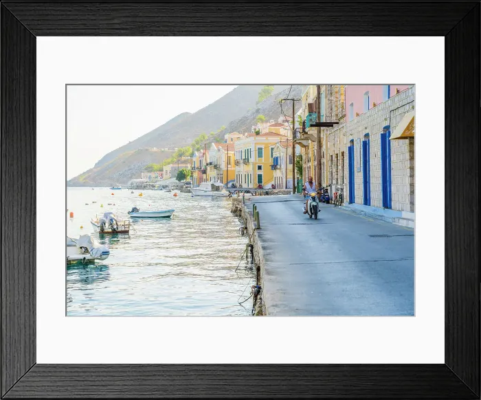 Framed Print : A man riding a motor cycle by the colourful harbour in Symi, Dodecanese Islands, Greece Framed Print : A man riding a motor cycle by the colourful harbour in Symi, Dodecanese Islands, Greece