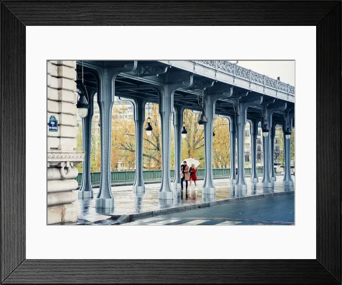Framed Print : Pont de Bir Hakeim, bridge in Paris, France. Couple walking in a rainy day