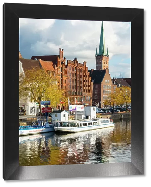 Boats on Trave river, traditional houses and St Petri Lubeck Church in background, Lubeck, UNESCO, Schleswig-Holstein, Germany