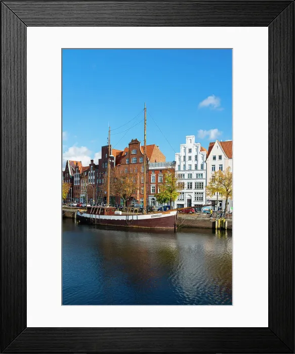 Framed Print : Boat anchored on Trave river and houses with traditional gables in background, Lubeck, UNESCO, Schleswig-Holstein, Germany Framed Print : Boat anchored on Trave river and houses with traditional gables in background, Lubeck, UNESCO, Schleswig-Holstein, Germany
