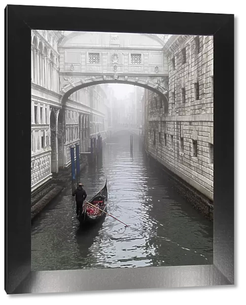 Italy, Veneto, Venice, a gondola moves towards the bridge of Sighs on a foggy day