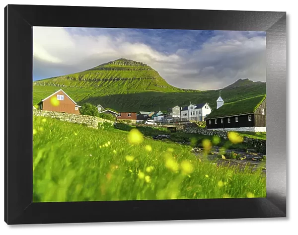 Funningur church and village surrounding by flowering meadows in summer, Eysturoy Island, Faroe Islands