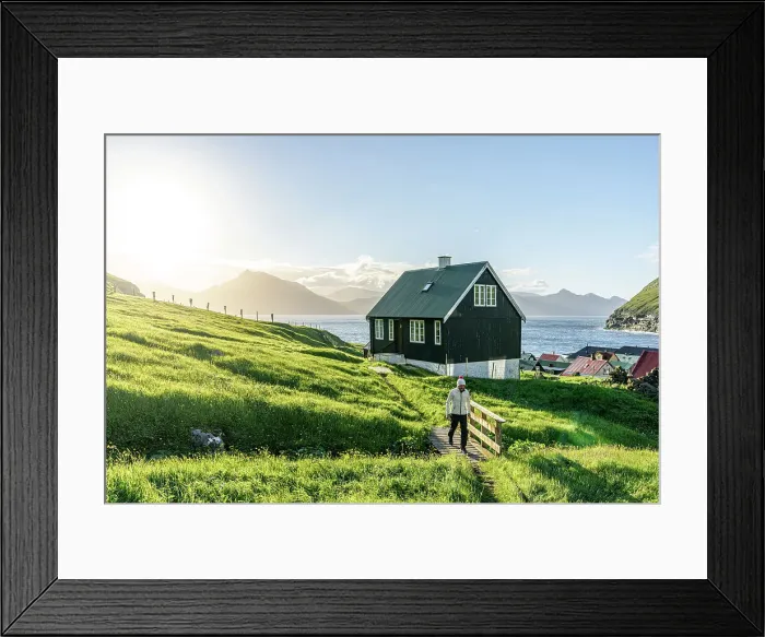 Framed Print : Tourist walking in the green landscape surrounding the coastal village of Gjogv, Eysturoy Island, Faroe Islands (MR)