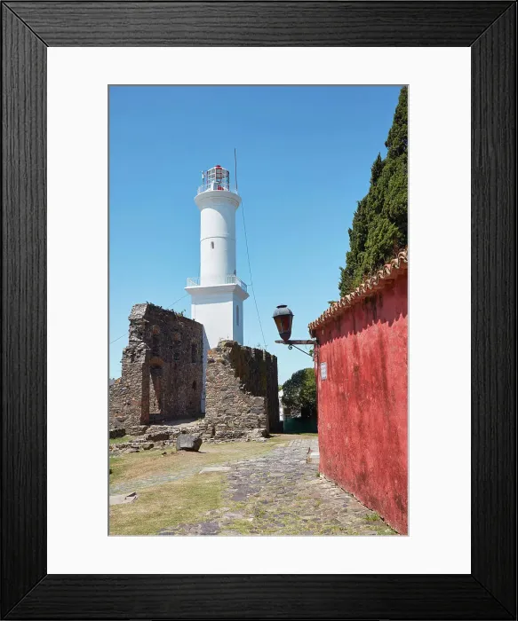 Framed Print : The lighthouse and a Portuguese traditional house in the historical cask of Colonia del Sacramento, Uruguay. Colonia was declared UNESCO World Heritage Site in 1995