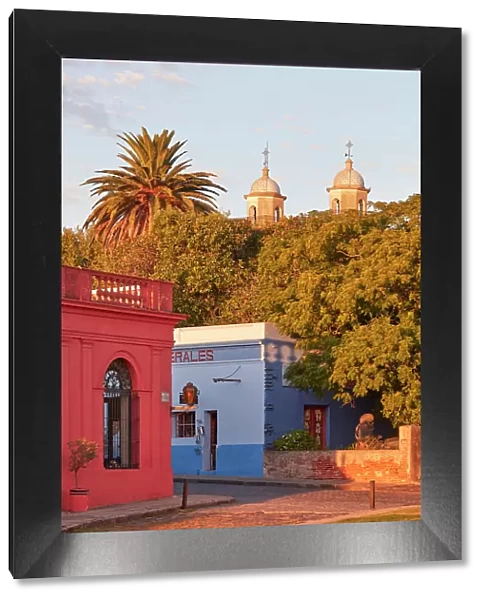 The 'Basilica of the Holy Sacrament' tower bells and colonial buildings at sunset, Colonia del Sacramento, Uruguay. Colonia was declared UNESCO World Heritage Site in 1995