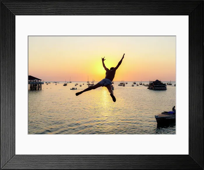 Framed Print : Cheerful young man jumping into the sea at sunset, Stone Town, Zanzibar, Tanzania Framed Print : Cheerful young man jumping into the sea at sunset, Stone Town, Zanzibar, Tanzania