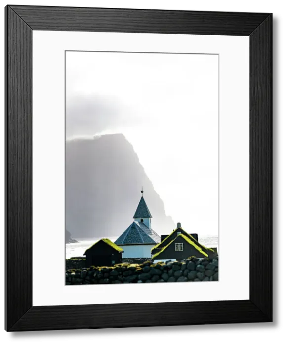 Framed Print : Misty sky over the traditional church of Vidareidi ovelooking a fjord, Vidoy Island, Faroe Islands Framed Print : Misty sky over the traditional church of Vidareidi ovelooking a fjord, Vidoy Island, Faroe Islands