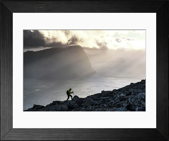 Framed Print : Man with backpack climbing a mountain above the fjord lit by sun rays at sunset, Vidoy Island, Faroe Islands (MR) Framed Print : Man with backpack climbing a mountain above the fjord lit by sun rays at sunset, Vidoy Island, Faroe Islands (MR)