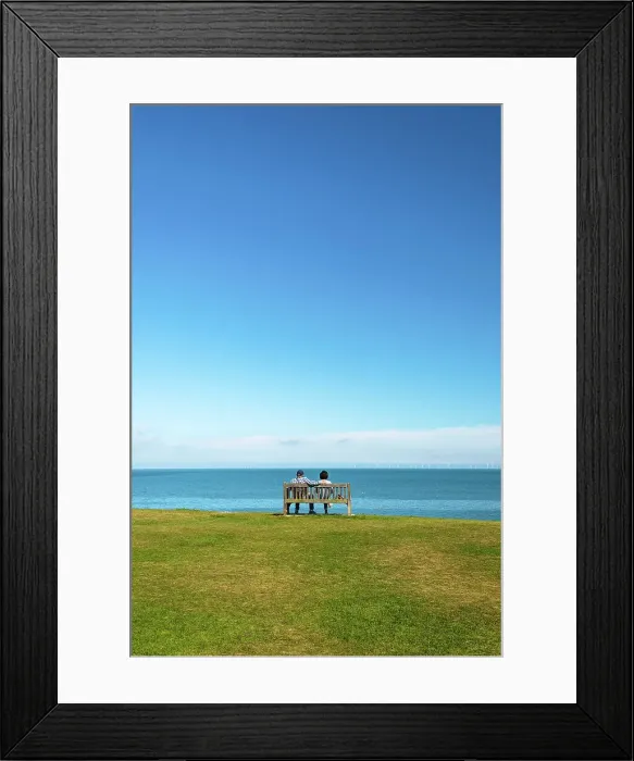 Framed Print : A couple sitting on a bench, enjoying a sea view over Tankerton Beach, near Whitstable, Kent, England Framed Print : A couple sitting on a bench, enjoying a sea view over Tankerton Beach, near Whitstable, Kent, England