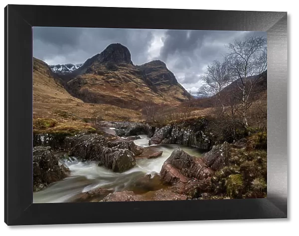River Coe rushing through Glencoe valley beneath the Three Sisters mountains, Highlands, Scotland, UK. Spring (March) 2023