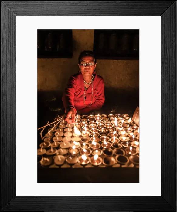Framed Print : Woman lighting devotional candles in temple at Swayambhunath Stupa, Kathmandu, Nepal Framed Print : Woman lighting devotional candles in temple at Swayambhunath Stupa, Kathmandu, Nepal
