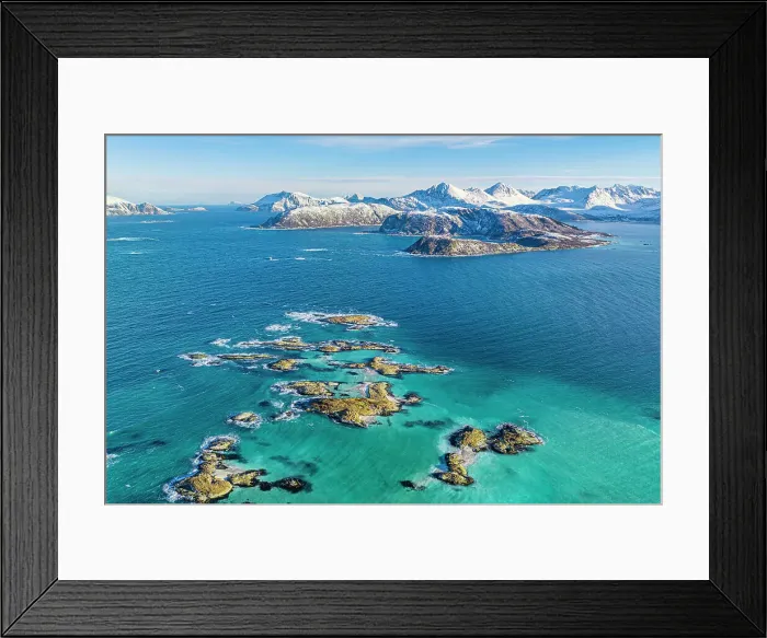 Framed Print : Aerial view of cliffs in the turquoise water of the cold sea with snowy mountains on background, Sommaroy, Troms county, Norway Framed Print : Aerial view of cliffs in the turquoise water of the cold sea with snowy mountains on background, Sommaroy, Troms county, Norway