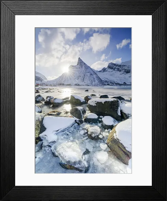 Framed Print : Sun rays over Hatten mountain peak overlooking the frozen sea, Ersfjord beach, Senja island, Troms county, Norway Framed Print : Sun rays over Hatten mountain peak overlooking the frozen sea, Ersfjord beach, Senja island, Troms county, Norway
