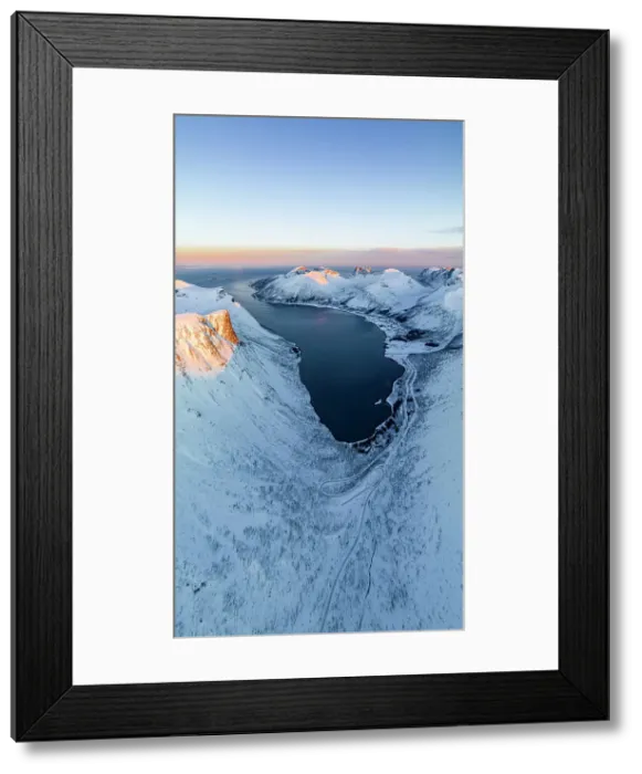Framed Print : Overhead view of a snowy mountain road leading to Bergsfjord village overlooking the icy sea, Senja, Troms county, Norway Framed Print : Overhead view of a snowy mountain road leading to Bergsfjord village overlooking the icy sea, Senja, Troms county, Norway