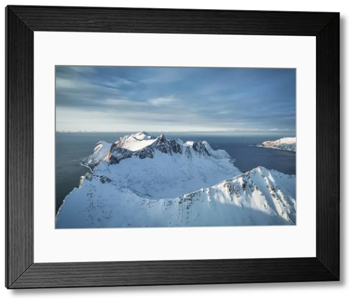 Framed Print : Dramatic sky over the snowcapped peaks of Hesten and Ytste-Kongen mountains, aerial view, Senja, Troms county, Norway Framed Print : Dramatic sky over the snowcapped peaks of Hesten and Ytste-Kongen mountains, aerial view, Senja, Troms county, Norway