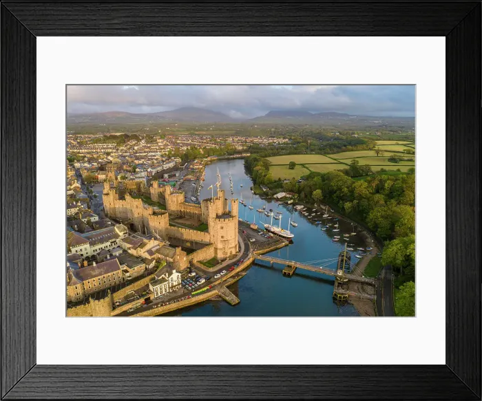 Framed Print : Aerial view of Caernarfon Castle and town in gorgeous evening sunlight, Caernarfon, Wales, UK. Spring (May) 2023 Framed Print : Aerial view of Caernarfon Castle and town in gorgeous evening sunlight, Caernarfon, Wales, UK. Spring (May) 2023