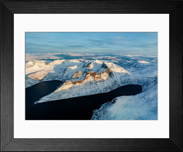 Framed Print : Aerial view of Oksfjord village and Grytetippen mountain covered with snow overlooking the cold sea, Senja, Troms county, Norway Framed Print : Aerial view of Oksfjord village and Grytetippen mountain covered with snow overlooking the cold sea, Senja, Troms county, Norway