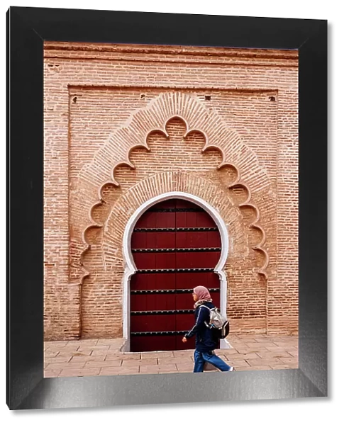 Woman student and typical arab door, Marrakech, Morocco