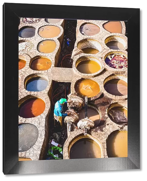 High angle view of man working at the vats of colours in the tannery of Fes, Morocco