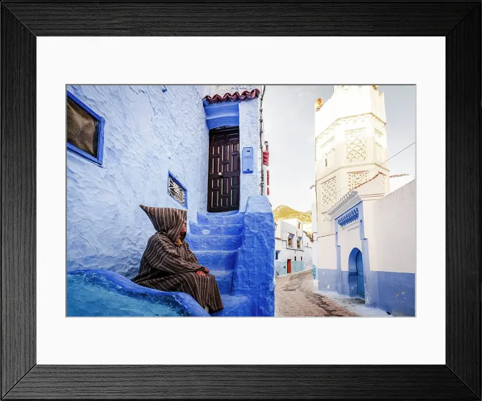 Framed Print : Man with traditional Djellaba looking at white tower of minaret sitting in the blue old town of Chefchaouen, Morocco Framed Print : Man with traditional Djellaba looking at white tower of minaret sitting in the blue old town of Chefchaouen, Morocco