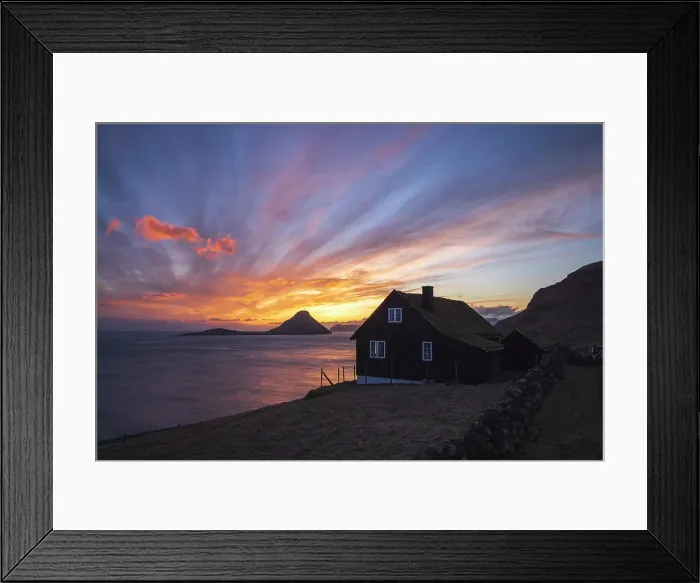 Framed Print : A traditional turf house and a spectacular sunset in Velbastaður. Island of Streymoy. The island of Koltur in the background. Faroe Islands
