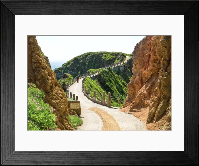 Framed Print : A walker crossing La Coupee, an isthmus joining Great Sark and Little Sark, three metres wide and with a drop of 80 metres on either side, Isle of Sark, Channel Islands (MR) Framed Print : A walker crossing La Coupee, an isthmus joining Great Sark and Little Sark, three metres wide and with a drop of 80 metres on either side, Isle of Sark, Channel Islands (MR)