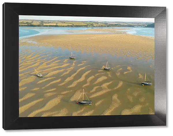 Aerial image of boats stranded on sand bars in the Camel Estuary, Rock, Cornwall, England. Summer (August) 2022