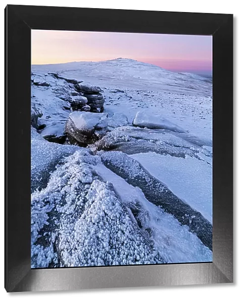 Snow and ice covered moorland at dawn on West Mill Tor in Dartmoor National Park, Devon, England. Winter (December) 2022