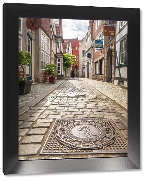 Bronze gully cover with Bremen city coat of arms in the historic Schnoor district, Bremen, Germany