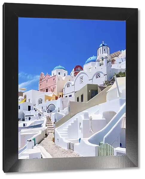 Iconic blue domed churches of Saint Spyridon and Resurrection of the Lord, low angle view, Oia Village, Santorini or Thira Island, Cyclades, Greece