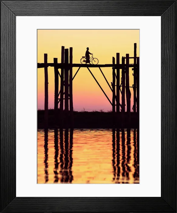 Framed Print : Silhouette of a person with a bicycle walking on the U-Bein wooden teak bridge at sunset, Taungthaman Lake, Amarapura, Mandalay, Myanmar Framed Print : Silhouette of a person with a bicycle walking on the U-Bein wooden teak bridge at sunset, Taungthaman Lake, Amarapura, Mandalay, Myanmar